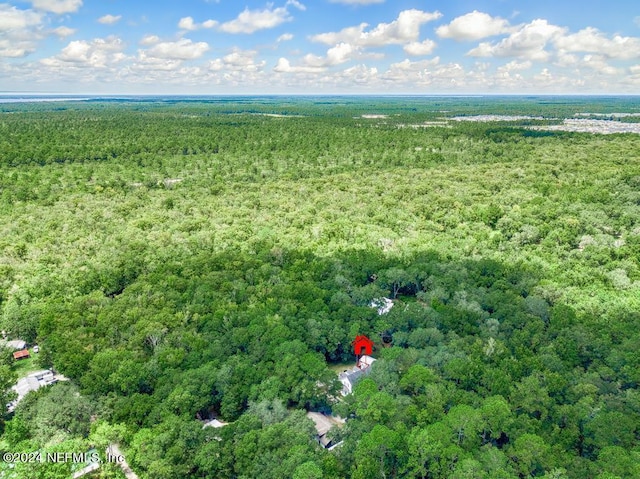 drone / aerial view featuring a wooded view