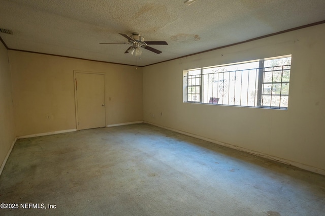 carpeted empty room featuring ceiling fan, ornamental molding, and a textured ceiling