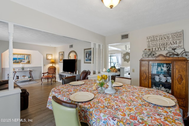 dining area featuring hardwood / wood-style flooring and a textured ceiling