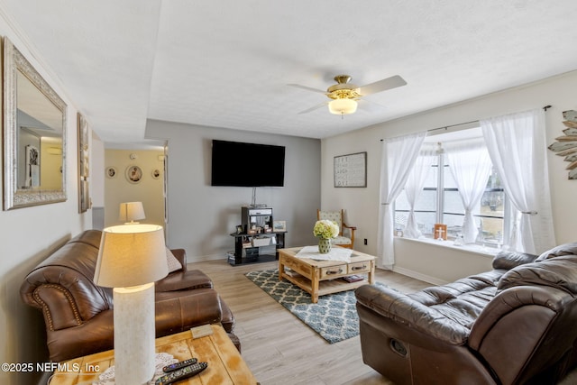 living room with a textured ceiling, light hardwood / wood-style flooring, and ceiling fan