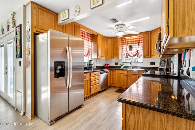 kitchen with ceiling fan, appliances with stainless steel finishes, sink, and light wood-type flooring