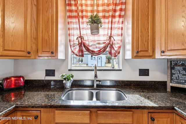 kitchen featuring sink and dark stone countertops