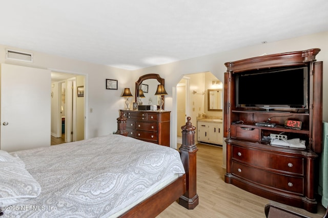 bedroom featuring ensuite bathroom and light hardwood / wood-style flooring