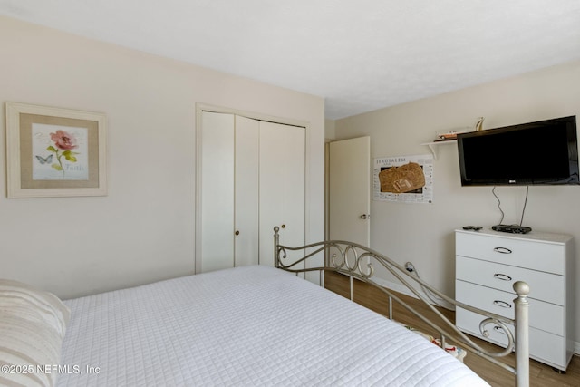 bedroom with light hardwood / wood-style floors and a closet