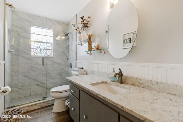 bathroom with hardwood / wood-style flooring, vanity, a shower with door, and toilet