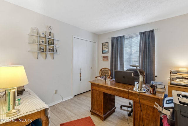 office space featuring a textured ceiling and light hardwood / wood-style floors