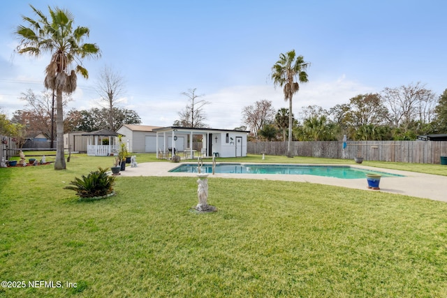 view of swimming pool featuring a storage unit, a yard, and a patio area