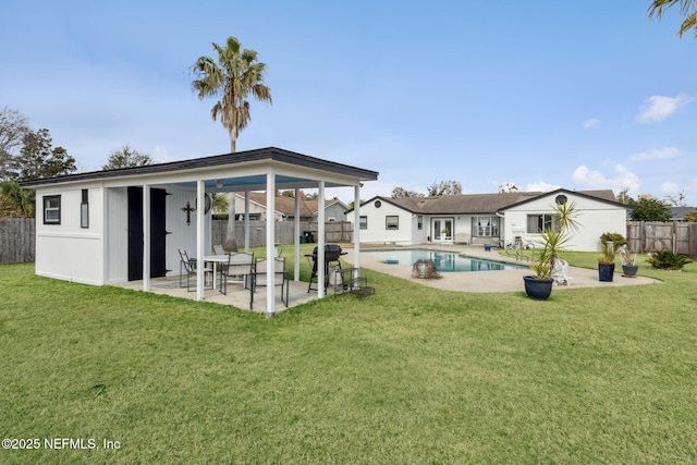 rear view of house featuring a fenced in pool, a patio area, and a lawn