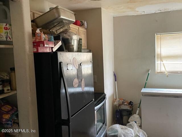 kitchen featuring black fridge, fridge, and range