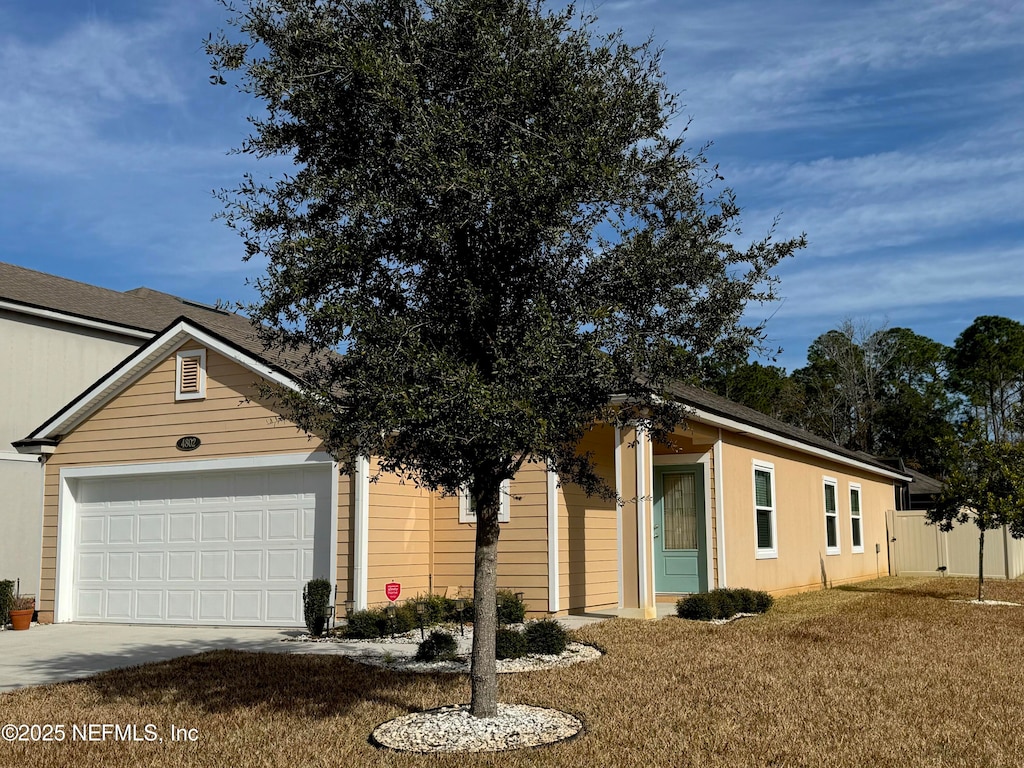 ranch-style home featuring a garage and a front yard