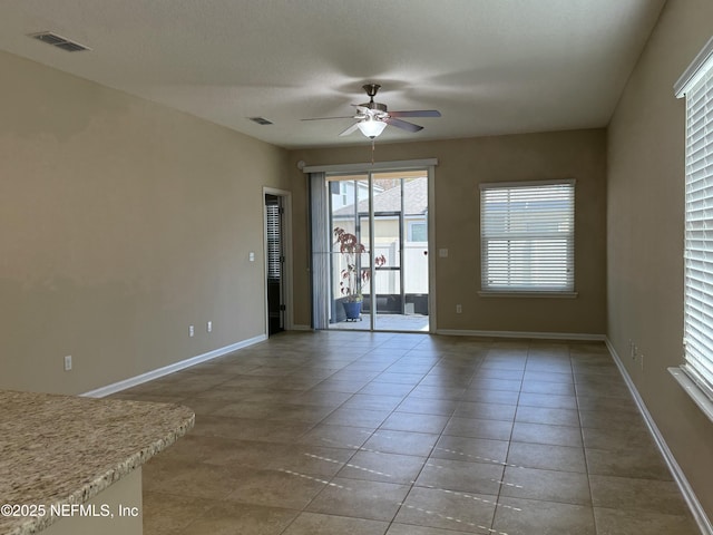 tiled spare room featuring a textured ceiling and ceiling fan