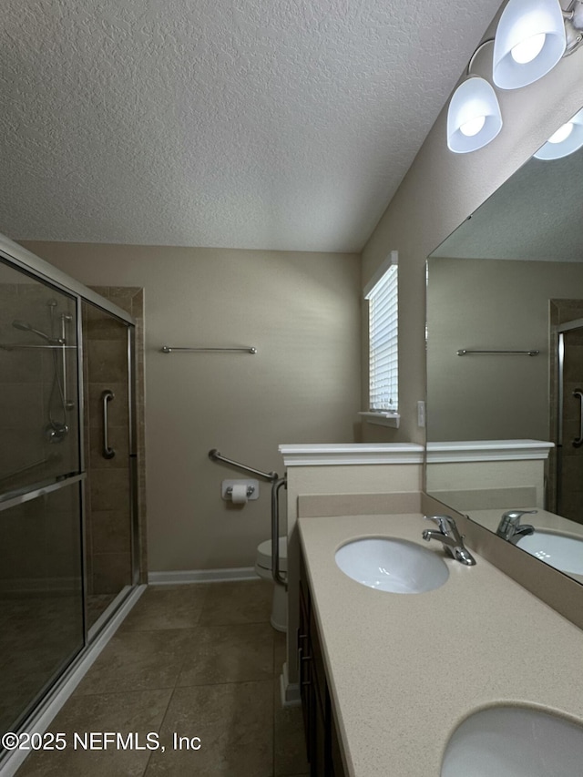 bathroom with tile patterned flooring, vanity, an enclosed shower, and toilet