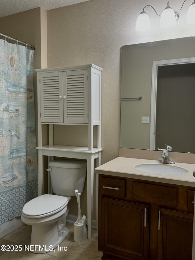 bathroom with tile patterned flooring, vanity, and toilet