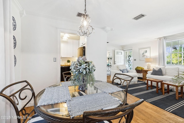 dining room featuring crown molding, a chandelier, and hardwood / wood-style floors