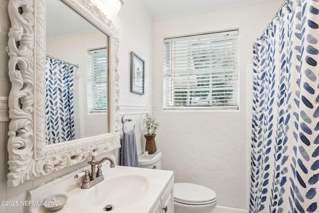 bathroom with crown molding, vanity, and toilet