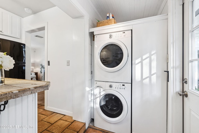 washroom with stacked washing maching and dryer