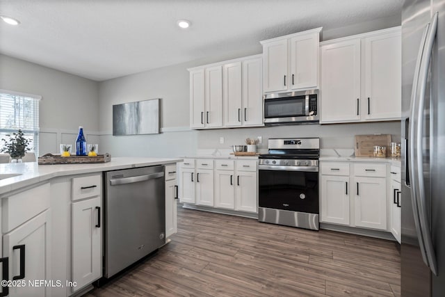 kitchen with white cabinetry, dark wood-type flooring, and stainless steel appliances