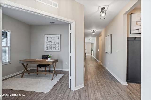 corridor with hardwood / wood-style floors