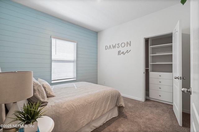 carpeted bedroom featuring wood walls