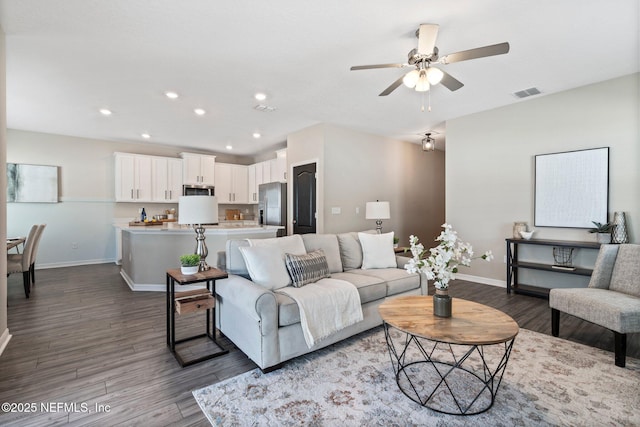 living room with dark hardwood / wood-style flooring and ceiling fan