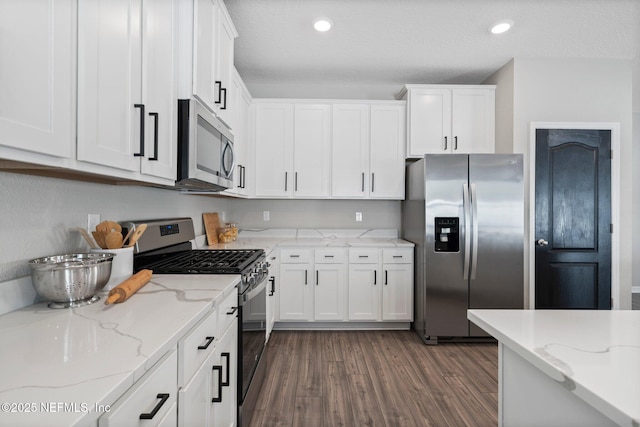 kitchen featuring stainless steel appliances, dark wood-type flooring, white cabinets, and light stone counters