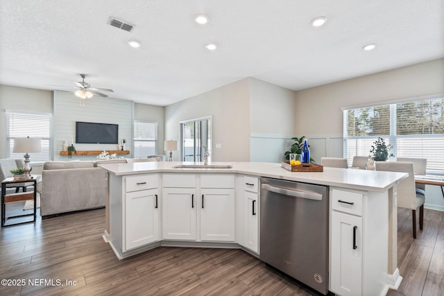 kitchen with white cabinetry, stainless steel dishwasher, an island with sink, and sink