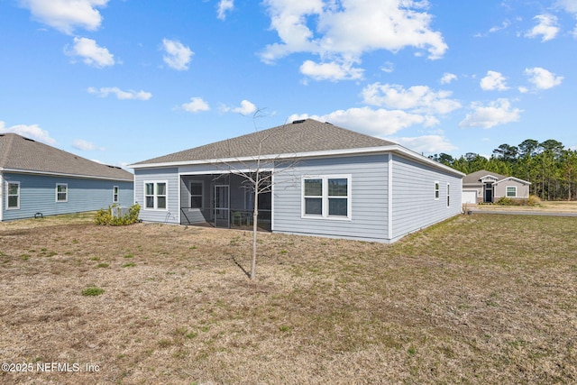 back of property featuring a sunroom and a lawn