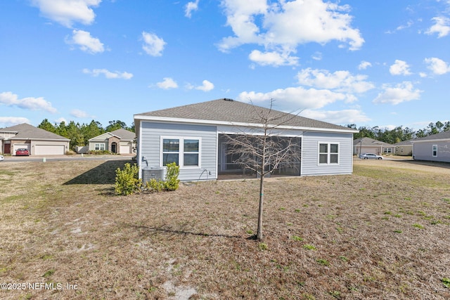 rear view of house with a yard and central AC