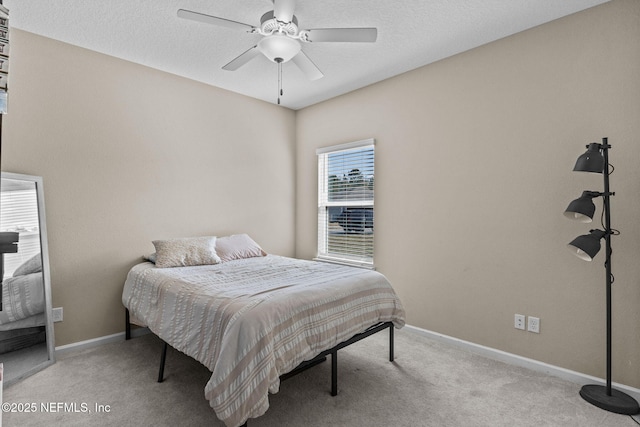 carpeted bedroom with ceiling fan and a textured ceiling