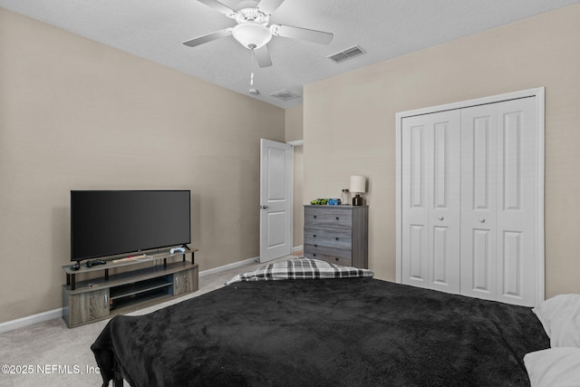 carpeted bedroom featuring a textured ceiling, ceiling fan, and a closet