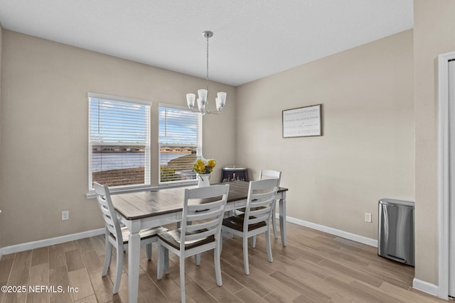 dining room featuring light hardwood / wood-style flooring and a chandelier