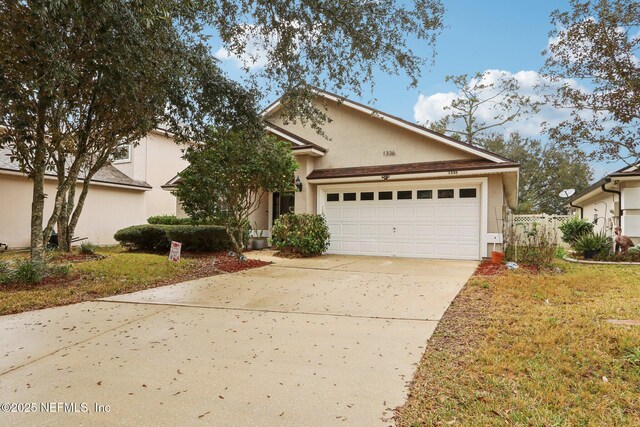 1336 River City St, Saint Augustine, FL 32092 - view of front of home featuring driveway, fence, an attached garage, and stucco siding