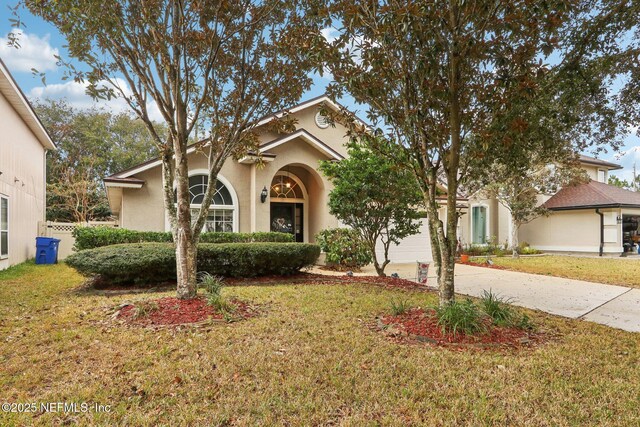 1336 River City St, Saint Augustine, FL 32092 - view of front of house with a front yard, driveway, and stucco siding