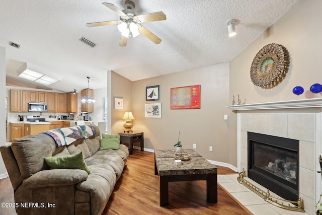 1336 River City St, Saint Augustine, FL 32092 - living area featuring light wood finished floors, visible vents, vaulted ceiling, and a textured ceiling