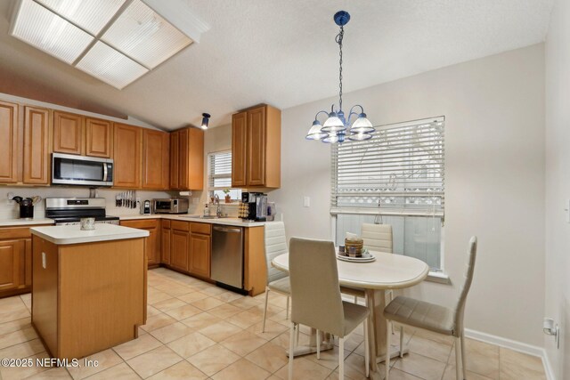 1336 River City St, Saint Augustine, FL 32092 - kitchen with a kitchen island, vaulted ceiling, stainless steel appliances, light countertops, and a sink