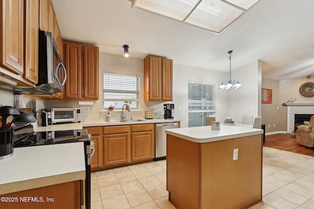 1336 River City St, Saint Augustine, FL 32092 - kitchen with a toaster, brown cabinetry, appliances with stainless steel finishes, a fireplace, and a sink