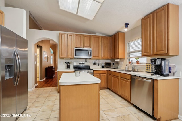 1336 River City St, Saint Augustine, FL 32092 - kitchen featuring a center island, arched walkways, lofted ceiling, appliances with stainless steel finishes, and a sink