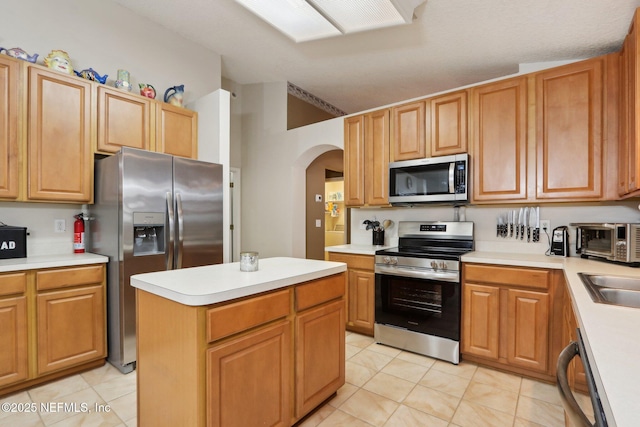 1336 River City St, Saint Augustine, FL 32092 - kitchen with arched walkways, stainless steel appliances, light countertops, and a center island