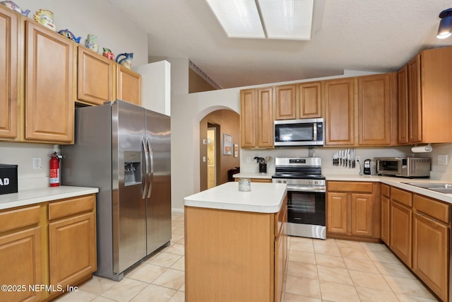 1336 River City St, Saint Augustine, FL 32092 - kitchen featuring arched walkways, a kitchen island, appliances with stainless steel finishes, light countertops, and light tile patterned flooring