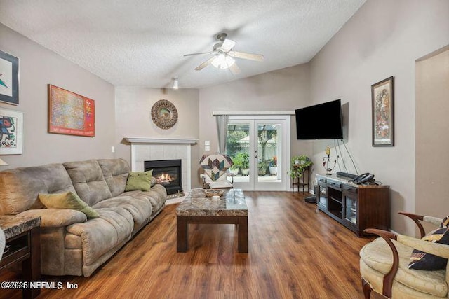 1336 River City St, Saint Augustine, FL 32092 - living area with a textured ceiling, a tile fireplace, wood finished floors, vaulted ceiling, and french doors