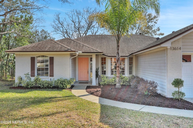 single story home with a garage and a front lawn