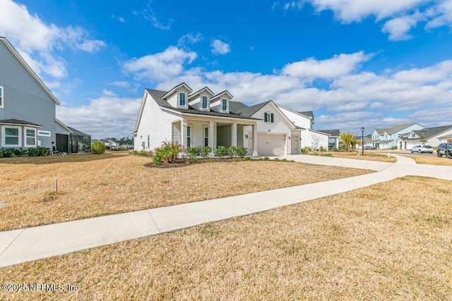 view of front of house with a garage, a front lawn, and a porch