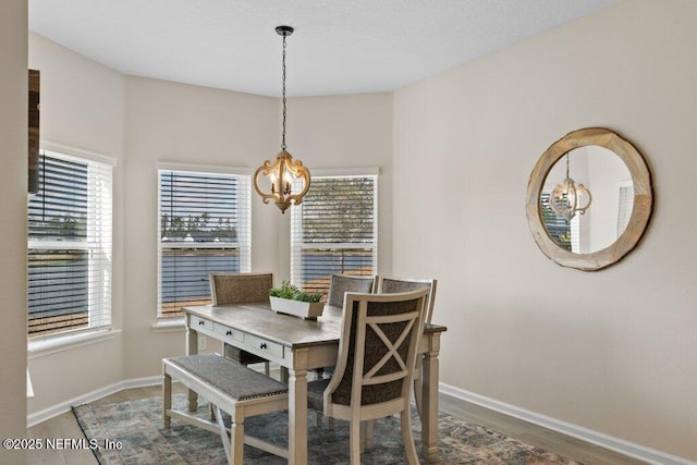 dining area with hardwood / wood-style floors and a chandelier