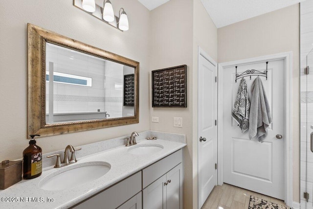 bathroom with hardwood / wood-style flooring, vanity, and walk in shower