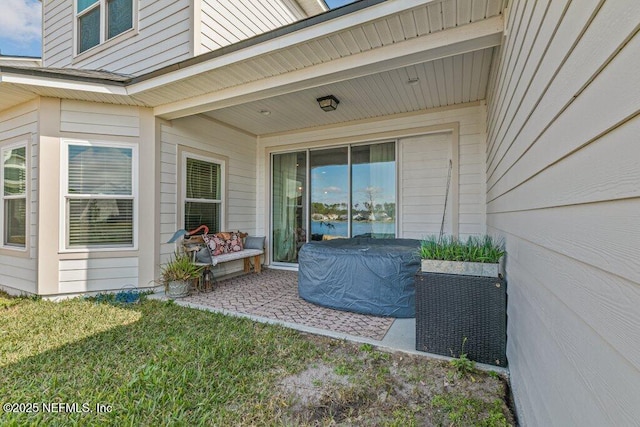 doorway to property with a patio and a yard
