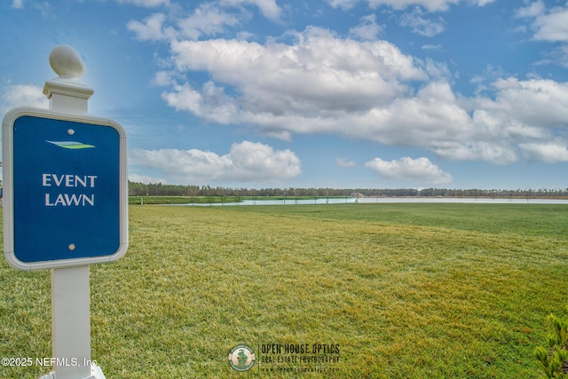 surrounding community with a water view and a lawn