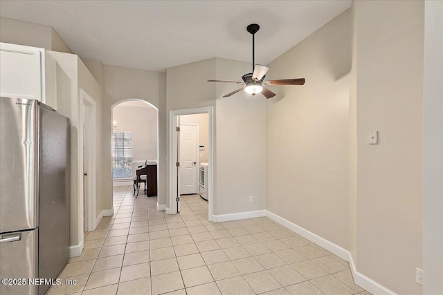 tiled empty room with ceiling fan and washer / clothes dryer