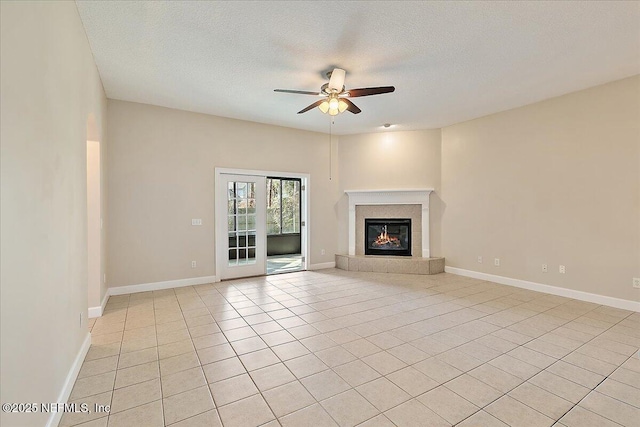 unfurnished living room with ceiling fan, a textured ceiling, and light tile patterned floors