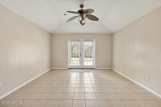 spare room with vaulted ceiling, light tile patterned floors, ceiling fan, a textured ceiling, and french doors