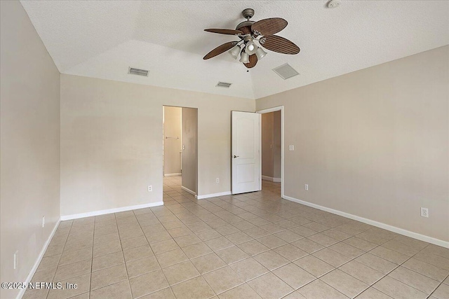 tiled empty room featuring vaulted ceiling, a textured ceiling, and ceiling fan